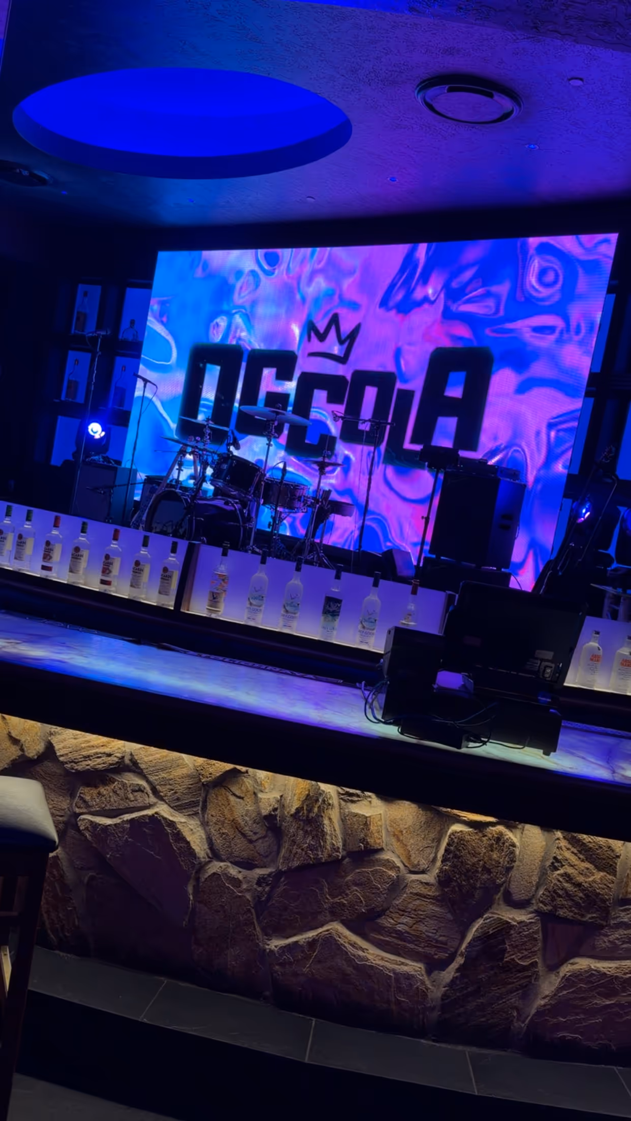 OG Cola stage setup with the logo glowing on the LED wall behind the drum kit